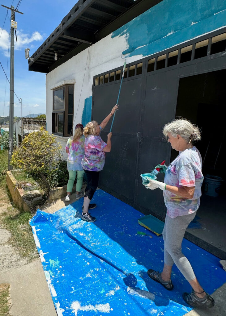 Volunteers with submersion14 paint a church in Peronia City, Guatemala.